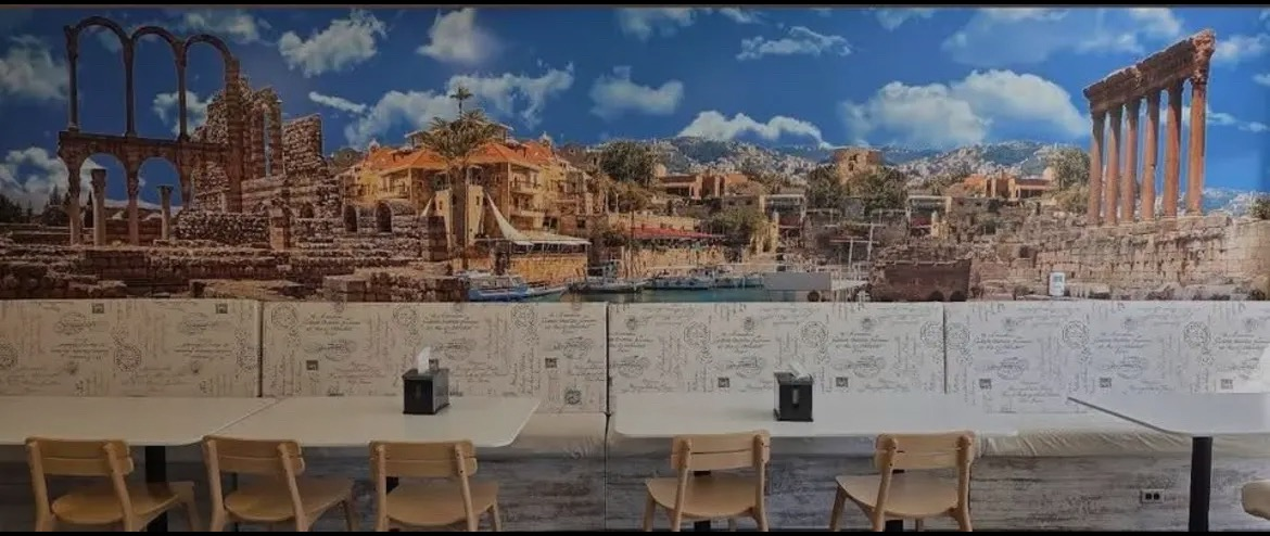 Mural of the Lebanese coast and ancient ruins behind the dining room